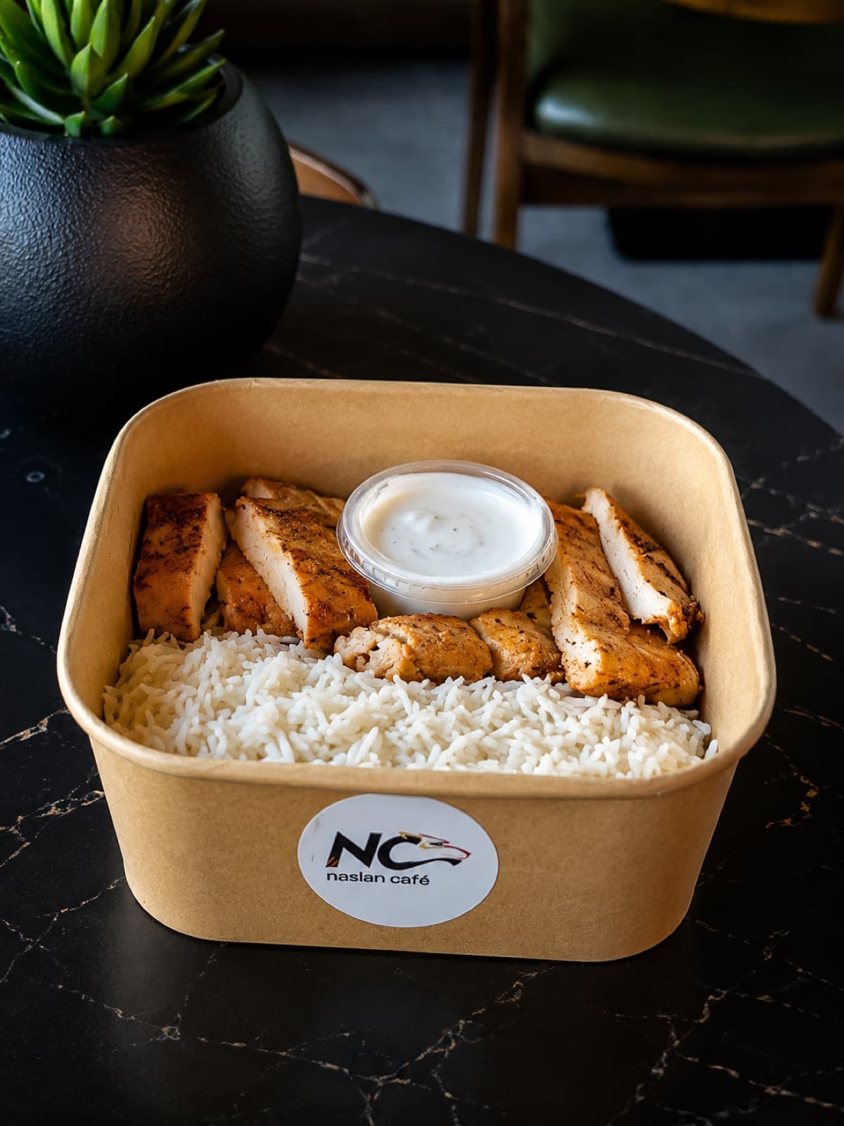 Grilled chicken and rice in a Naslan Café takeaway box