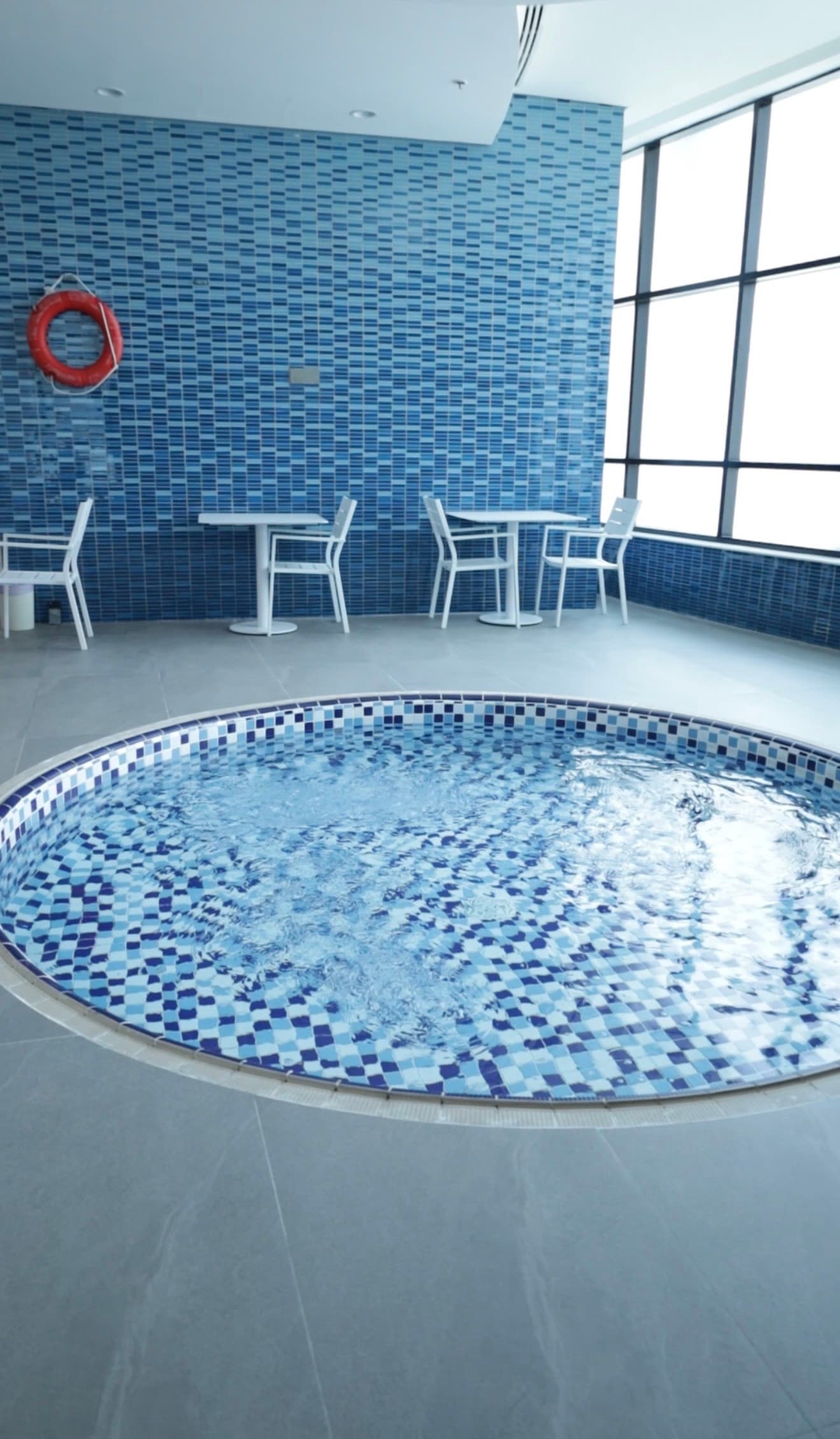 Round shallow kids pool with seating area and natural light